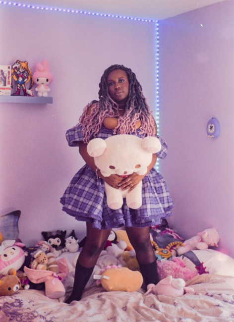 Portrait of Lenyx Dickey in a pastel bedroom full of cute stuffed animals.